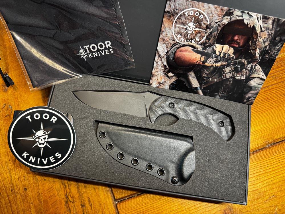 In this photograph, we see what is included with the Mullet S knife. A sheath plus assorted accessories come with a presentation box.