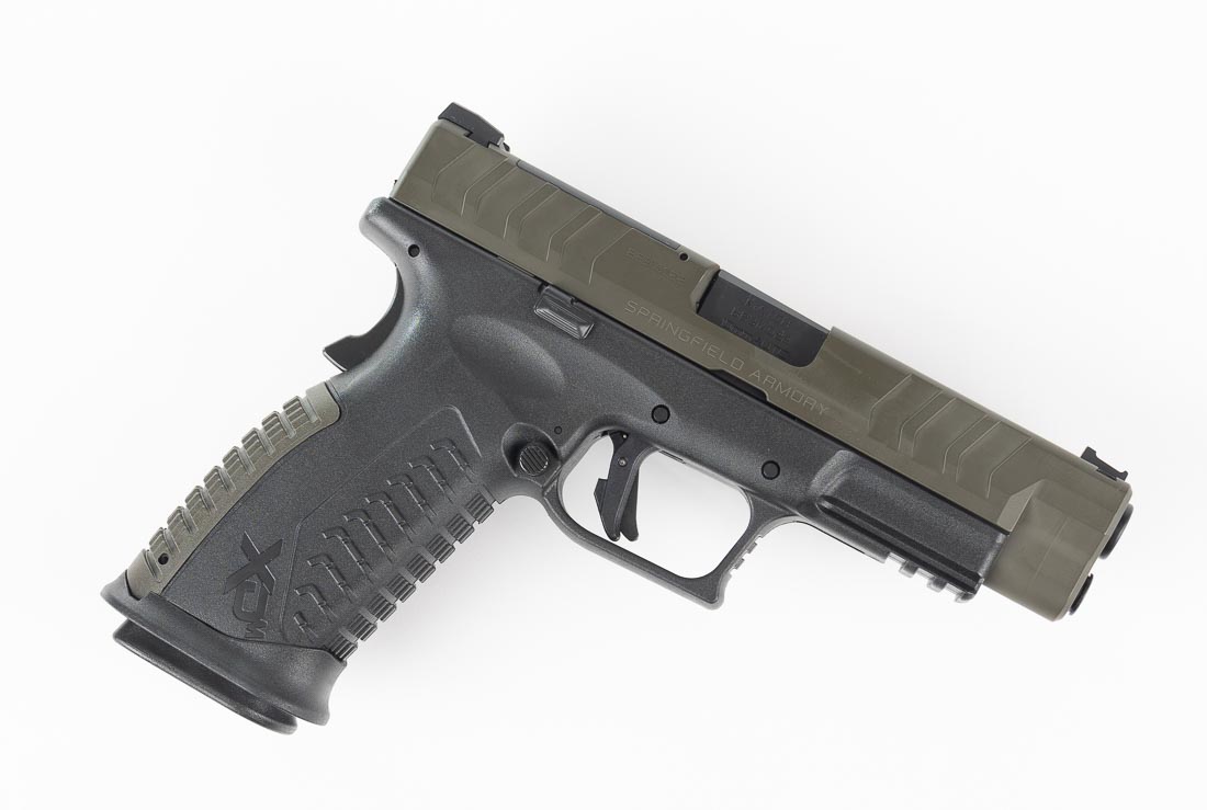 A Springfield Armory XD-M Elite OSP pistol chambered in 10mm Auto is shown with an OD Green Cerakote slide and black polymer frame. This Sportsman’s Warehouse exclusive model features the same 4.5-inch match-grade barrel, optic-ready slide cut, and ambidextrous controls as the standard XD-M Elite. The pistol includes a fiber optic front sight and U-notch rear sight, both mounted on the forged steel slide. The green Cerakote finish adds a unique visual distinction while protecting the steel against corrosion and wear. Like all XD-M Elite 10mm models, it carries 16+1 rounds, making it suitable for defensive, hunting, and range use. The grip texture and integrated safety are visible in the photo, reinforcing ergonomic design and user safety. This image highlights the exclusive OD Green finish while confirming identical function across the Elite series.