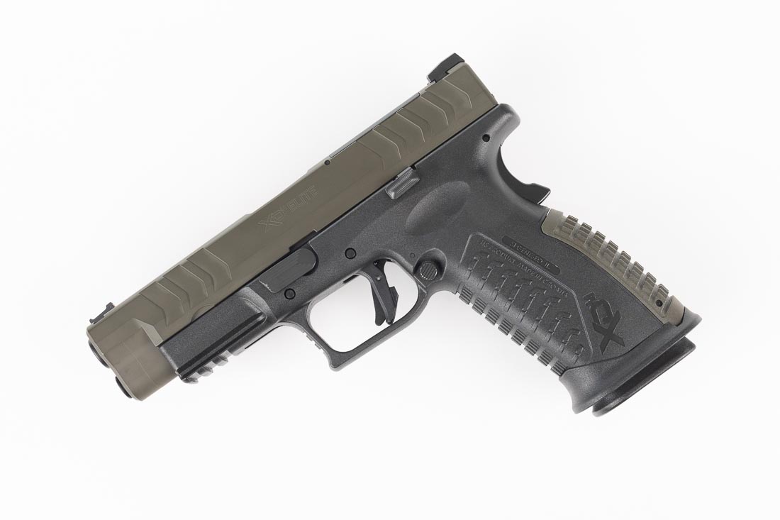 A Springfield Armory XD-M Elite OSP 10mm pistol is shown in the Sportsman’s Warehouse exclusive configuration. The handgun features a Magpul OD Green Cerakote slide paired with a black polymer frame. The optic-ready slide cut is visible along with the fiber optic front sight and tactical U-notch rear sight. The pistol retains the same 4.5-inch match-grade barrel, striker-fired action, and ambidextrous controls as other XD-M Elite variants. Its grip safety and interchangeable backstraps are also visible in the photo. The combination of color and finish makes this model distinct while maintaining the same durability and reliability. This image illustrates the cosmetic difference of the Sportsman’s Warehouse edition while reinforcing its shared performance features.
