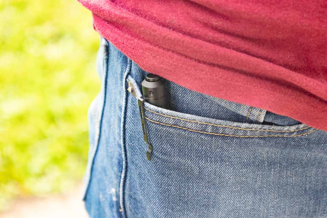 The Princeton Tec Alloy-X flashlight is clipped inside the author’s front pants pocket, with only the top portion and steel pocket clip visible. The slim, penlight-style design sits flush against the fabric, avoiding any noticeable bulge. This discreet carry makes it well-suited for office wear, slacks, or jeans without affecting comfort. The matte black aluminum body blends with the clip, giving it a clean and unobtrusive appearance. The light’s small footprint ensures it won’t snag or shift during daily movement. Designed for up to 400 lumens, the Alloy-X combines tactical-level durability with a low-profile carry method. This image demonstrates its everyday carry compatibility for both professional and casual environments.