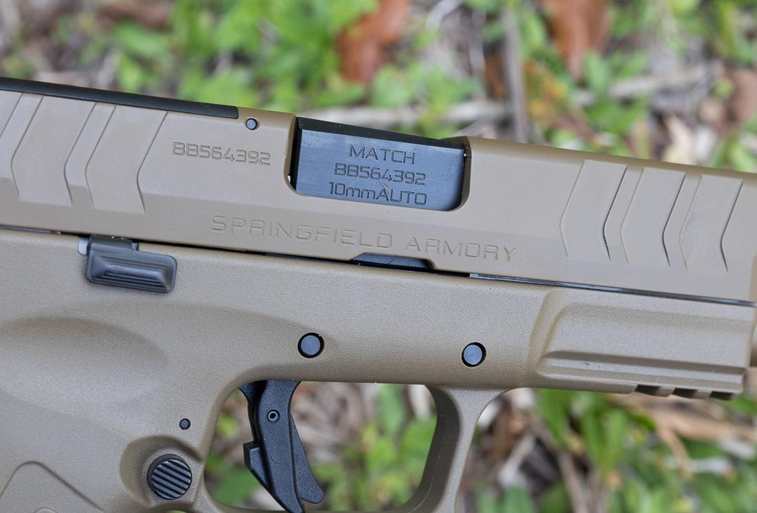 A close-up image of the Springfield Armory XD-M Elite OSP 10mm pistol’s match-grade barrel is shown. The barrel measures 4.5 inches and is made from hammer-forged steel. Springfield applies a Melonite treatment for increased durability, corrosion resistance, and wear protection. The chamber is cut for 10mm Auto, offering versatility with both practice and premium defensive ammunition. The tighter tolerances of the match-grade design support improved accuracy compared to standard barrels. During range testing, the barrel delivered consistent groups under three inches at 15 yards with multiple loads. This image emphasizes the quality and precision of the XD-M Elite barrel.