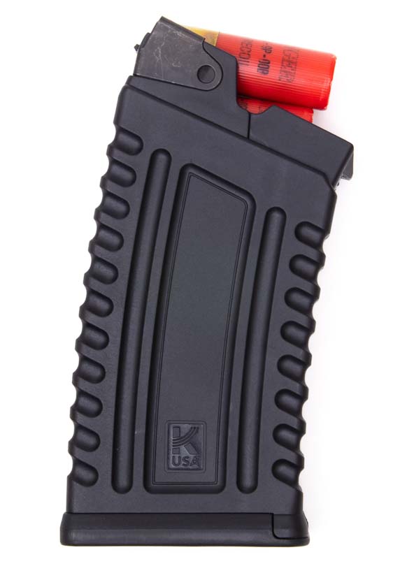 A single five-round Kalashnikov Komrad magazine appears fully loaded with 12-gauge shotshells visible through the magazine body, showcasing the AK-style box magazine design that accepts both 2.75-inch and 3-inch ammunition. The Kalashnikov Komrad review highlights magazine construction quality. Komrad 12 shotgun evaluation tests feeding reliability consistently. Detachable shotgun magazines simplify ammunition management. AK-pattern magazines feature textured polymer bodies. Box-magazine shotguns enable tactical reloading speed.