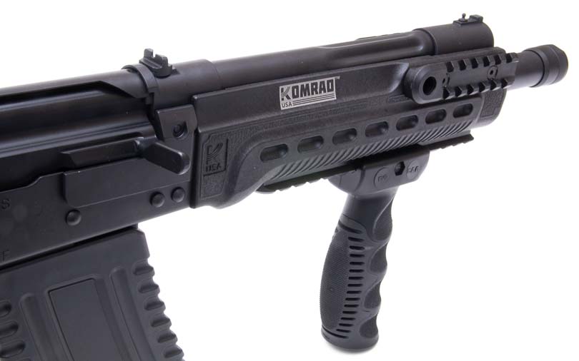 A close-up view of the Kalashnikov Komrad KS-12 fore-end reveals three Picatinny rails positioned for accessory mounting, including tactical lights, lasers, and foregrips, showcasing the firearm's modular customization capability. The Kalashnikov Komrad review examines accessory compatibility thoroughly. Komrad 12 shotgun evaluation highlights rail system versatility. Picatinny rail systems enable tactical light attachment. Modular shotgun platforms accept various accessories. Defensive firearms benefit from illumination tools.