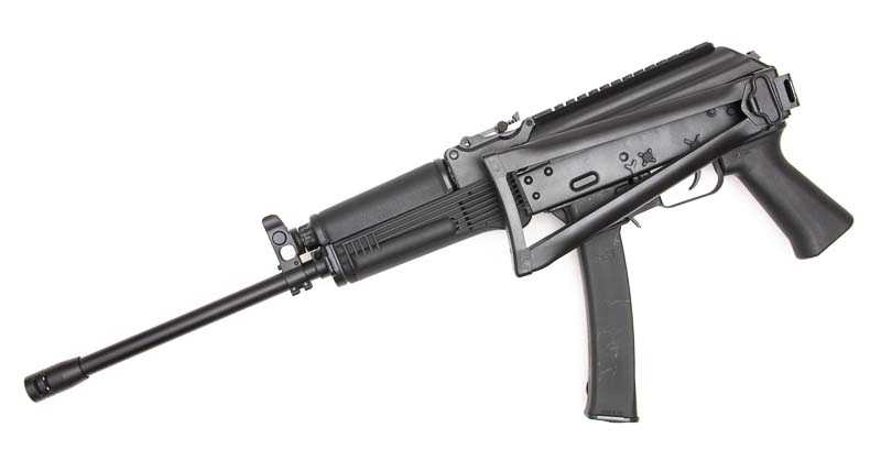 An image shows the KR-9 carbine's folding stock mechanism in its collapsed position against the receiver body. The KR-9 rifle demonstrates traditional Soviet folding stock engineering. Nine-millimeter carbines reduce overall dimensions for transport convenience. The KUSA 9mm pistol caliber carbine remains fireable when folded. Semi-automatic firearms benefit from compact folding stock designs. Defensive carbines maximize portability without sacrificing functionality.