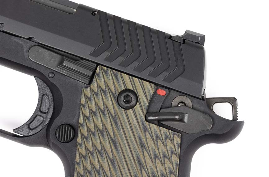 A detailed close-up shows the Springfield 911's frame-mounted ambidextrous thumb safety in the "safe" position, with the lever clearly visible on both sides of the aluminum frame. The Springfield 911 9mm review emphasizes the importance of manual safety training for carry users. Ambidextrous safety levers accommodate left-handed and right-handed shooters without modification. The Springfield Armory 911 features positive safety engagement with audible clicks. Manual safeties provide additional security layers during appendix carry positions. Single-action pistols require deliberate safety manipulation before firing capability.