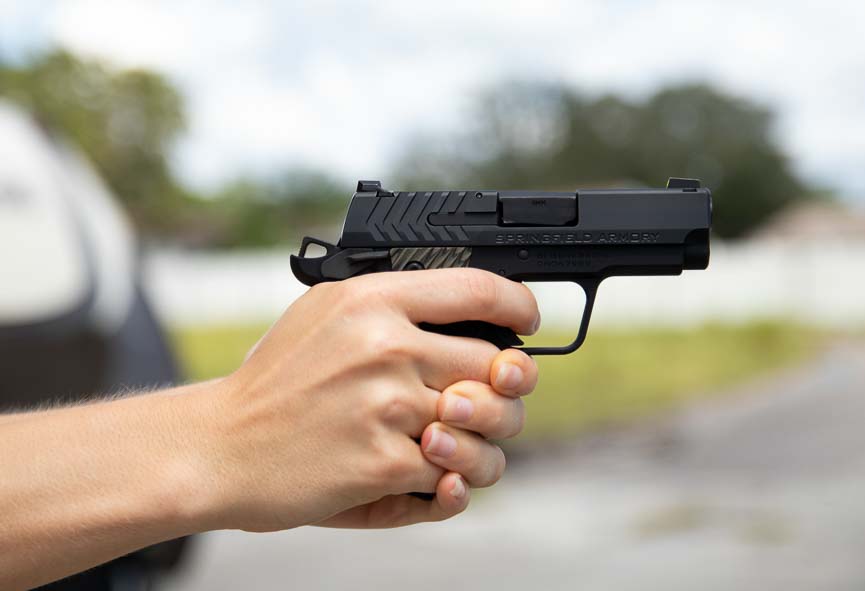 A woman holds the Springfield 911 9mm pistol with proper two-handed grip, demonstrating that the compact handgun suits shooters with smaller hands for concealed carry applications. The Springfield 911 9mm review confirms suitability for diverse shooter demographics and body types. Micro-compact pistols accommodate female shooters seeking effective defensive firearms. The Springfield Armory 911 provides manageable recoil for new and experienced carriers. Concealed carry options should fit individual hand size and strength capabilities. Defensive handguns empower personal protection regardless of shooter gender or stature.