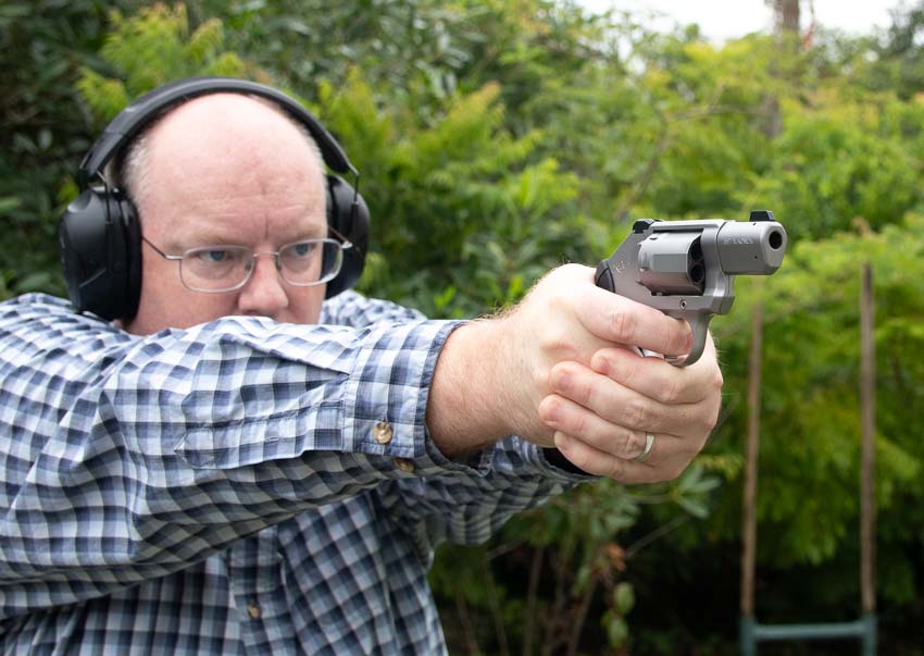 author shooting Kimber K6s during testing at outdoor shooting range